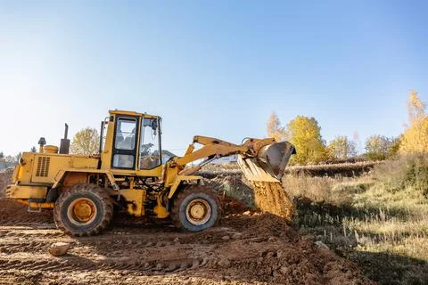 Large yellow wheel loader aligns a piece of land for a new building. Preparat Stock Photos