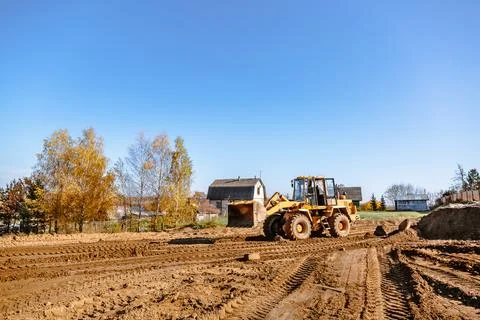 Large yellow wheel loader aligns a piece of land for a new building. Preparat Stock Photos