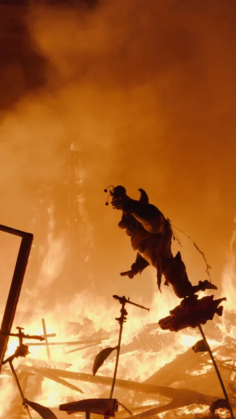 Las Fallas falla figure silhouette against intense fire glow during La Crema Stock Footage 334231541