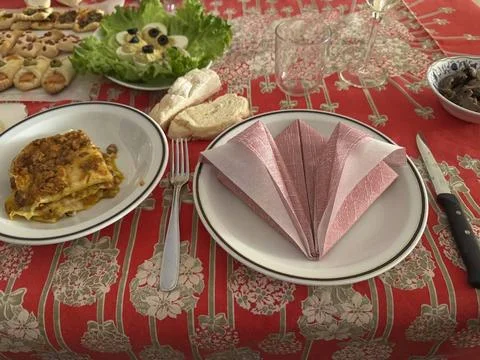  Lasagna is served on a table set for lunch with appetizers, bread, folded... Foto stock