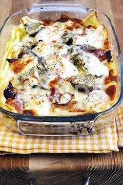 Lasagne with artichokes and ham in a baking dish Stock Photos