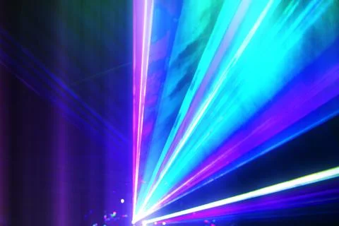 Laser blue and white rays of light on a dark background. Stock Photos