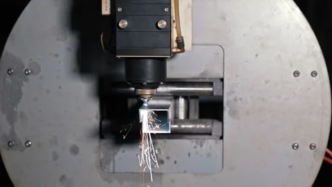 Laser cutting head positioned over metal pipe in CNC machine, Precision tube Stock Footage 309318542