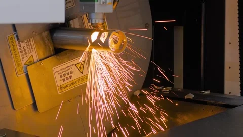 Laser cutting machine is operating on cylindrical metal workpiece with sparks Stock Footage 341322081