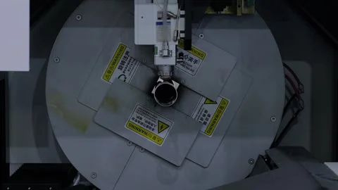 Laser cutting machine is operating on cylindrical metal workpiece with sparks Stock Footage 344605664
