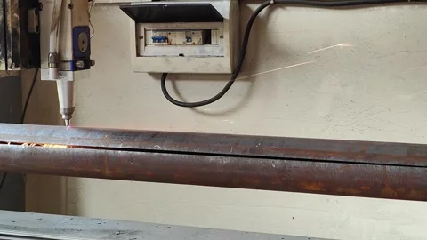 Laser cutting machine processing rusty metal pipe with flying sparks Stock Footage 342296676