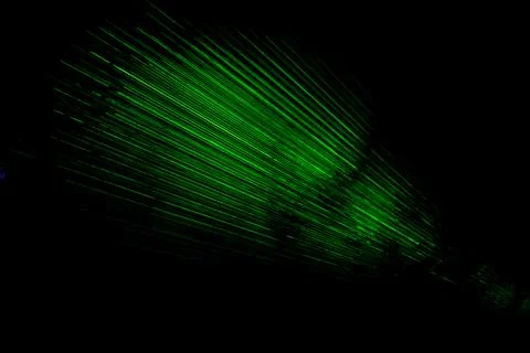 Laser in dark. Green rays on black background. Laser radiation in space. Stock Photos