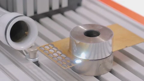 Laser engraving machine burning hole on flat metal sheet: close up Stock Footage 143932038