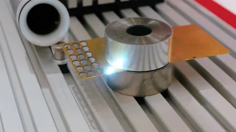 Laser engraving machine burning hole on flat metal sheet: close up Stock Footage 149926391