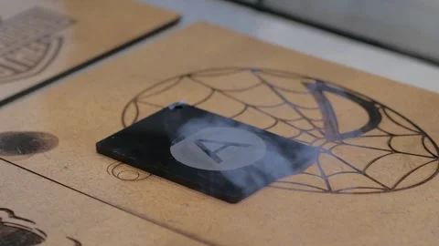 Laser engraving machine burns pattern on black acrylic sheet Stock Footage 329945678