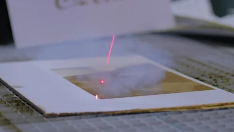 Laser engraving machine burns pattern on sheet of plywood - close up Stock Footage 347243448