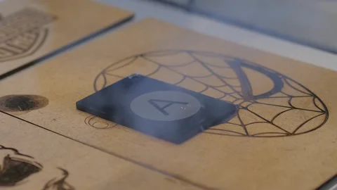 Laser engraving machine burns pattern on black acrylic sheet Stock Footage 347246650