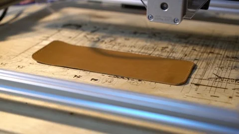Laser engraving machine work. 4K. Laser burns on cow skin logo. Leather purse Stock Footage 87156557