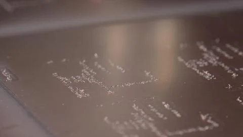 Laser engraving tiny lines on metal plate creating intricate design Foto stock