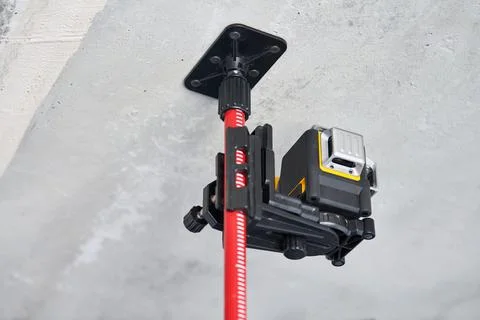 Laser level measuring tool at construction site or unfinished apartment, clos Stock Photos