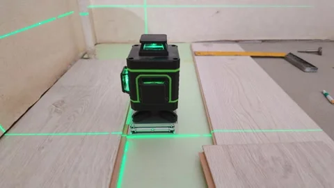 Laser level projecting green beams for flooring installation Stock Footage 326150197