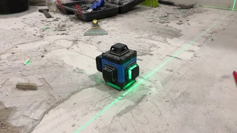 Laser level projects green lines onto the cement floor Stock-Footage 167265937