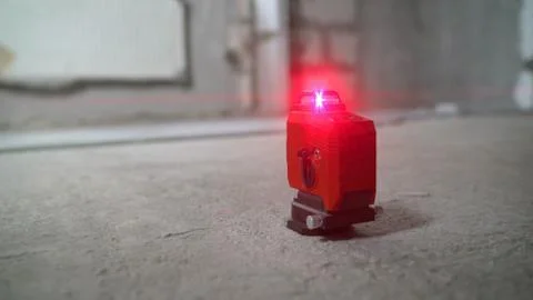 Laser level at work. Laser level and concrete walls and floor. Apartment reno Stock Photos