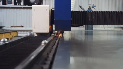 A laser machine cuts a sheet of metal moving over it. Laser cutting Stock Footage 108648335