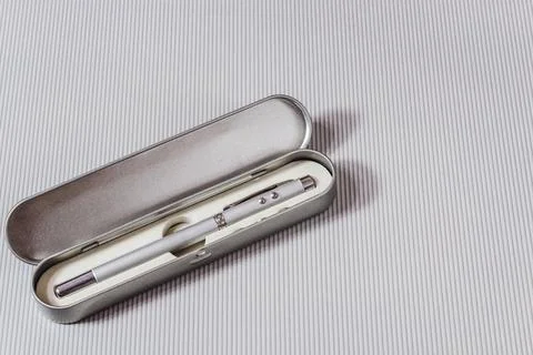 Laser pointer in the form of a telescopic stationery pen on a light backgroun Stock Photos