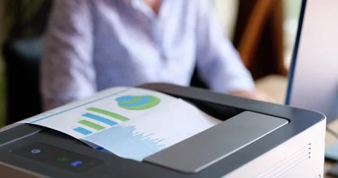 Laser printer outputs financial report filled with charts Stock Footage 312157500