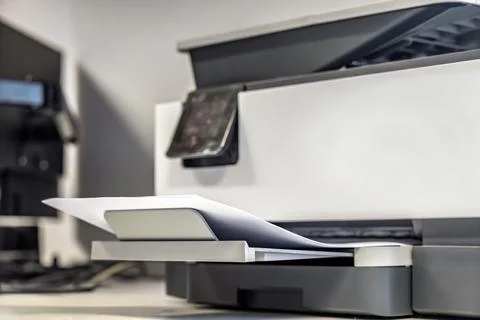 Laser printer with printed documents in output tray office workspace 스톡 사진