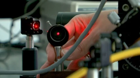 Laser setup in photonic lab. laser beam. hand  is placing lens to direct Stock Footage 121746452