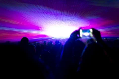 Laser show party rays in front of smartphone filming video. Best visual show  Stock Photos
