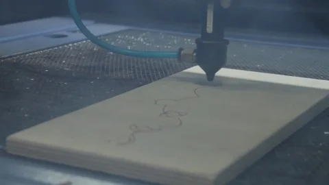 Laser torch is cutting a plywood plate. Laser cutting beam over plywood sheet Stock Footage