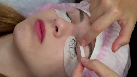 Lash Maker prepares the client's eyelashes for extension procedure Stock Footage 140711132