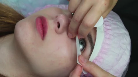 Lash Maker prepares the client's eyelashes for extension procedure Stock Footage 140711616