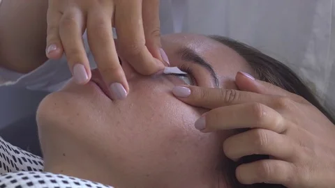 Lash master put protection on models eye. Eyelash extension in beauty studio. Stock Footage 75740773