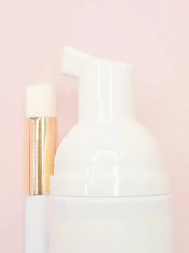 Lash shampoo bottle with applicator brush on soft pink background Stock Photos
