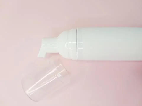 Lash shampoo bottle with clear cap on soft pink background for beauty concept Stock Photos