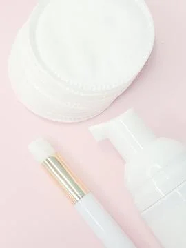 Lash shampoo concept with applicator and cotton pads on pink background Stock Photos