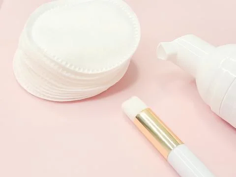 Lash shampoo concept with applicator and cotton pads on pink background Stock Photos
