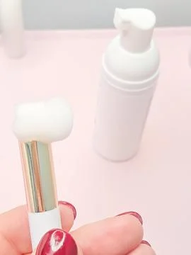 Lash shampoo concept with foam applicator and bottle on pink background Stock Photos