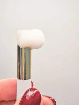 Lash shampoo concept with foam on applicator held by manicured hand Stock Photos