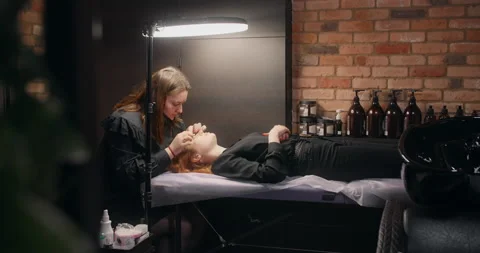 Lashmaker does the eyelash lamination procedure for the client in the beauty Stock Footage 152897473