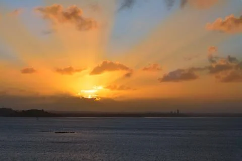 Last beams of setting sun breaking through the clouds Stock Photos