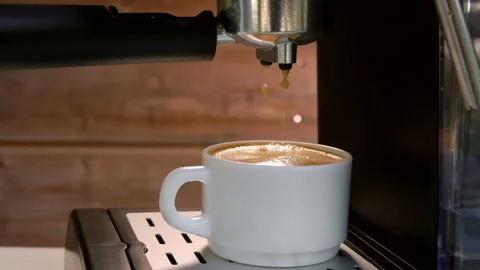 Last drops of coffee are falling into cup with espresso from the coffee machine Stock Footage 129118201