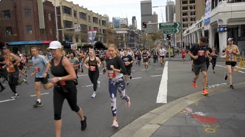 Last half of first wave of seeded red runners at start of race running up Stock Footage 114079306