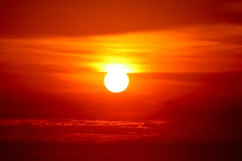 Last light of sunset on the red cloud orange sky and ray around sun Stockfoto's