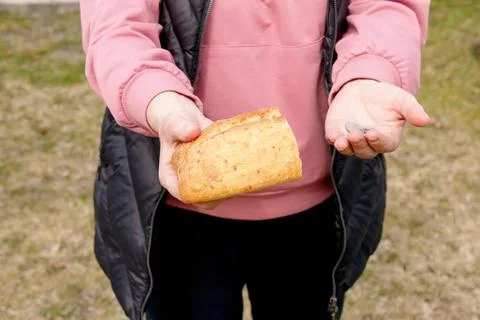 Last money for bread. Bread in the hand of a middle-aged woman. The concept o Stock Photos