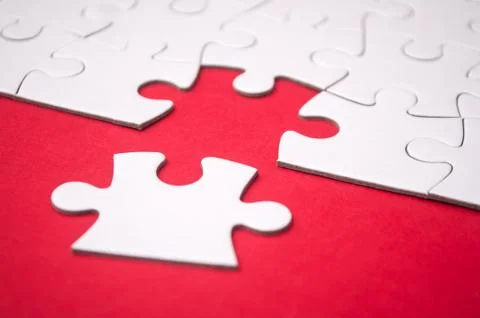 The last piece of jigsaw puzzle missing on red background Stock Photos
