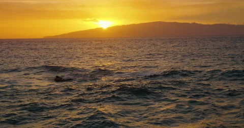 Last rays of orange setting sun over ocean and island La Gomera. Sea waves on Stock Footage 232898370