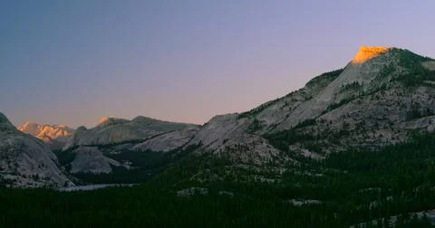 Last rays of sunlight crest the summit of Tenaya Peak in Yosemite National Park. Stock Photos