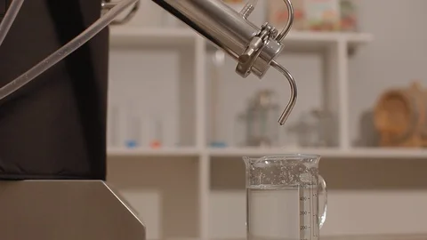 Last step of a Distillery Where Final Product of Alcohol comes out of Spigot for Stock Footage 129708401