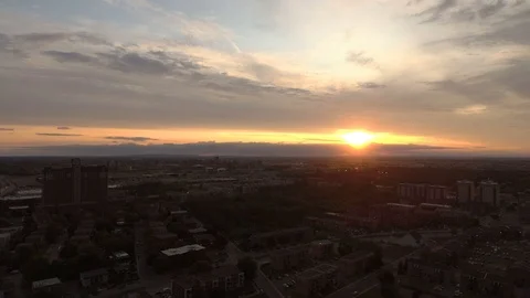Last strong rays of the sun piercing through clouds at dusk over urban area Stock Footage 114712497