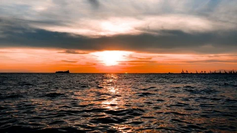 Last sunlight over the sea with container ship and industrial harbor Stock Footage 90607918